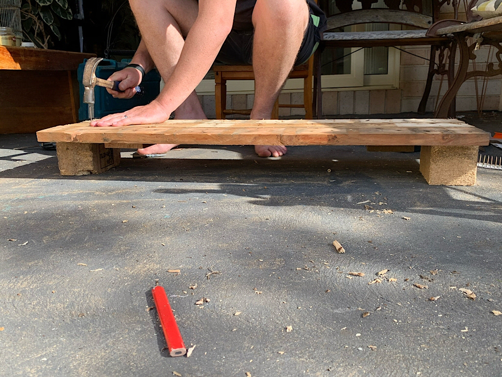 Nailing pallet wood together to make a raised bed